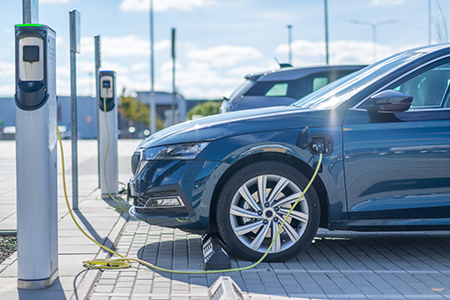 An EV plugged into a curbside charging station